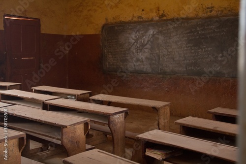Old wooden school benches and desks captured inside an abandoned classroom