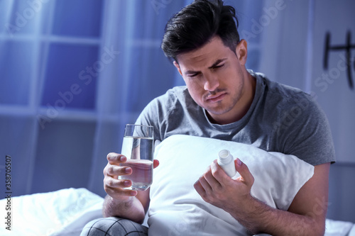 Young man taking sleeping p...
