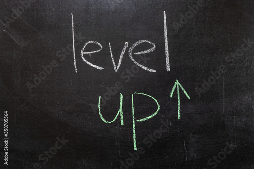 LEVEL UP text on a chalkboard, the concept of raising the level