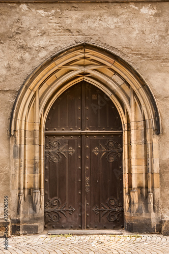Old church textured door with stone arch facade