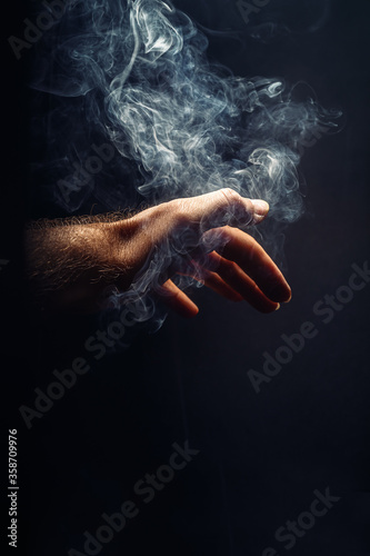 hand in smoke on black background.
