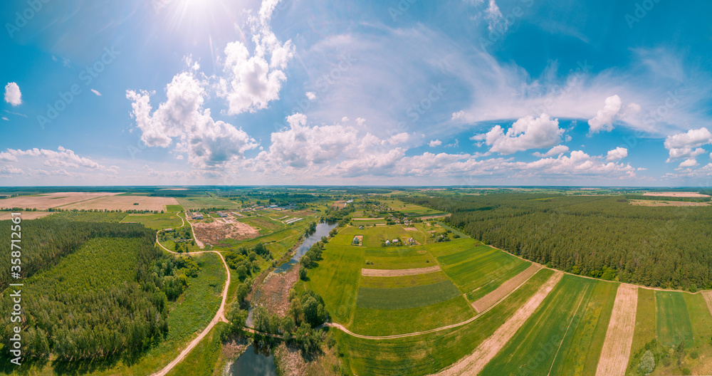 Rural landscape with beautiful sky, aerial view. Skyview of countryside. View of plowed and green fields and pine forest in spring. Panorama 180