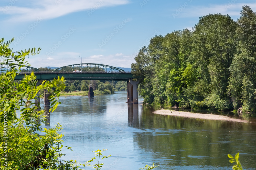 Willamette river in Albany, Oregon, and the bridge over it in summer season Willamette river in Albany, Oregon, and the bridge over it in summer season