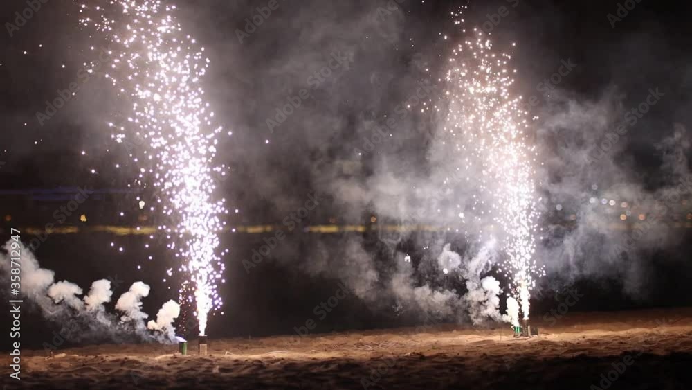 Small white firework burning on the beach Small white firework burning on the beach
