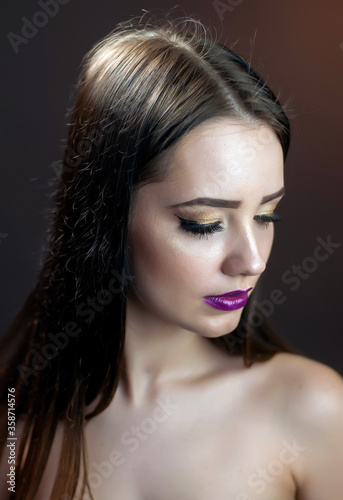 Fashion studio shot of young beautiful woman with bright makeup. Closeup