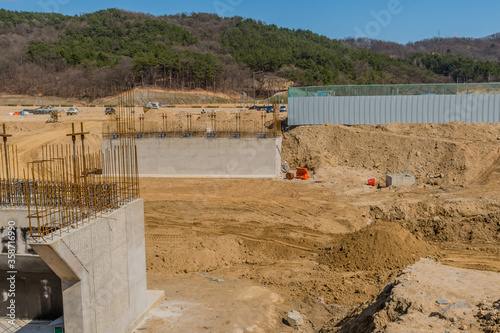 Two end of concrete overpass being built at construction site.