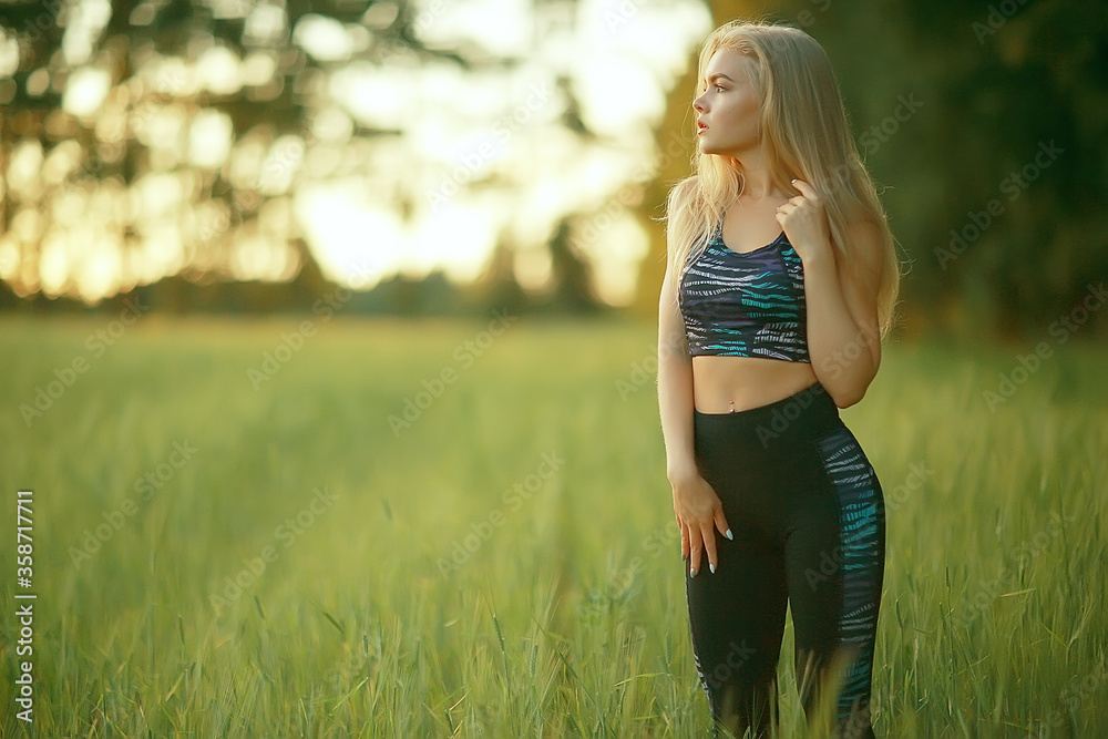 blonde long hair nature summer / happy adult girl with developing in the wind long blonde hair in the summer field