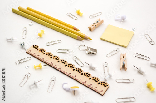 Assortment school or office yellow stationery, pencils, pins, clips, ruler, isolated on white background