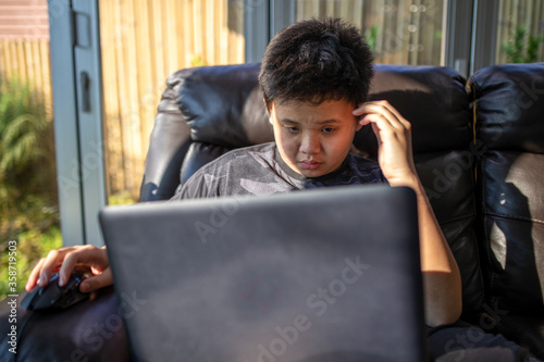 Asian boy uses laptop for studying from home