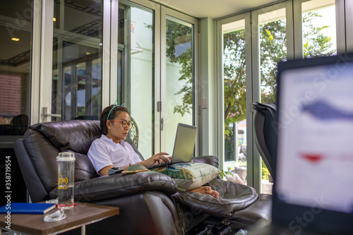 Asian woman uses laptop for working at home