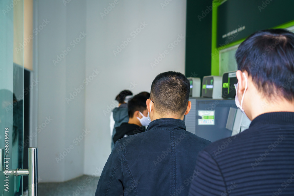 Closeup Asoam people queuing to withdraw cash in an ATM Closeup Asoam people queuing to withdraw cash in an ATM