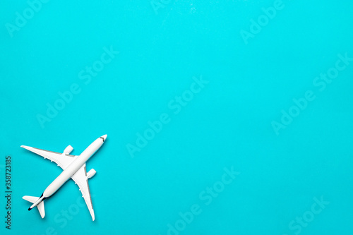 Kids playing toys. White airplane, aircraft in top view on bright blue backdrop. Flight air plane travel background with copy space for sky fly concept.