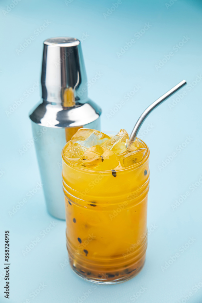 passion fruit lemonade in a bar glass with ice on a blue background passion fruit lemonade in a bar glass with ice on a blue background