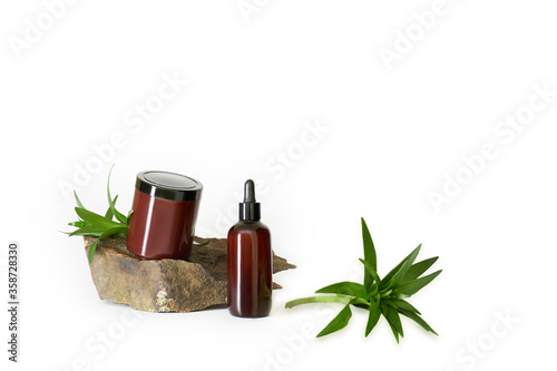 dark brown bottles cosmetics no label on natural dark stone with water lilies green leaves and on white background isolated