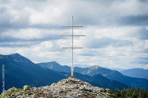 Summit cross and dramatic mountain landscape in the Carpathians, Ukraine