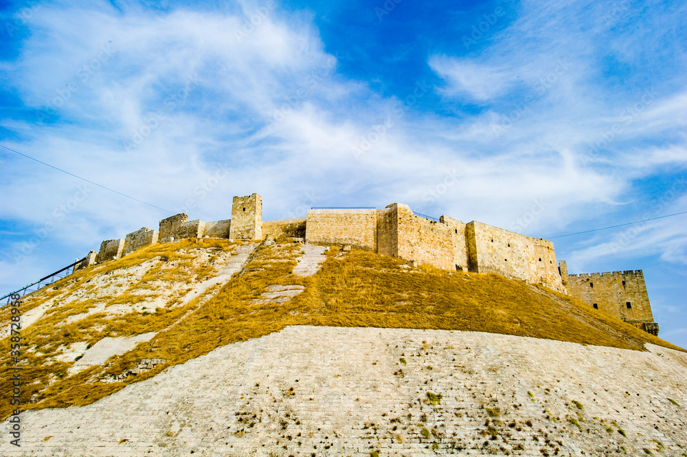 It's Citadel of Aleppo, a large medieval fortified palace of the old city of Aleppo, northern Syria.
