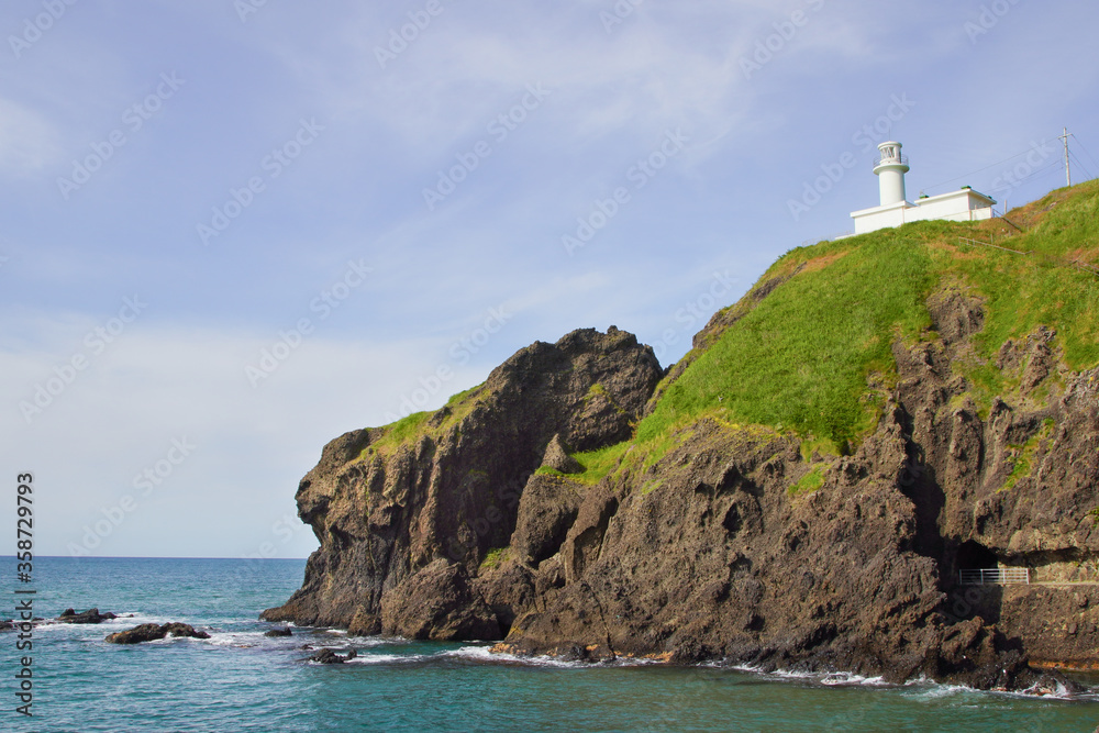 日本海の断崖の上に立つ白い灯台