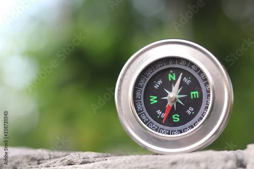 round compass on natural background as symbol of tourism