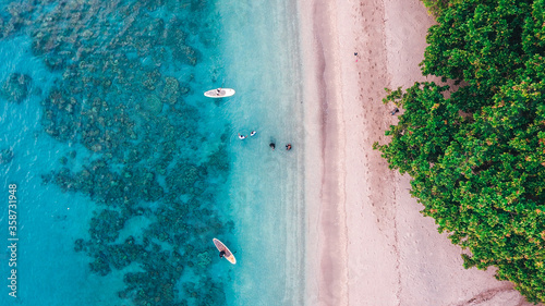Aerial drone birds eye view of tourists canoeing in tropical beach of Moyo Island, Sumbawa, Indonesia photo