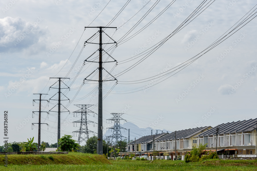 Kuching, Sarawak / Malaysia - June 21, 2016: Power poles and cables in residential housing area in overcast sky.