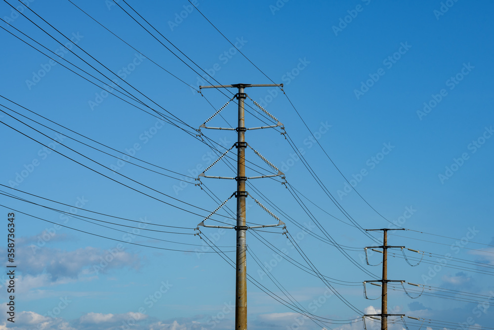 Kuching, Sarawak / Malaysia - August 28, 2017: Power pole and cables in blue sky. Kuching, Sarawak / Malaysia - August 28, 2017: Power pole and cables in blue sky.