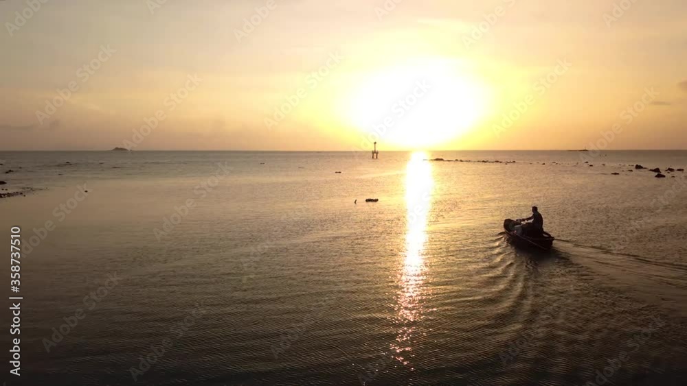 Drone aerial view of sunset and silhouette of man in fishing boat and scenic coastline of Thailand Drone aerial view of sunset and silhouette of man in fishing boat and scenic coastline of Thailand