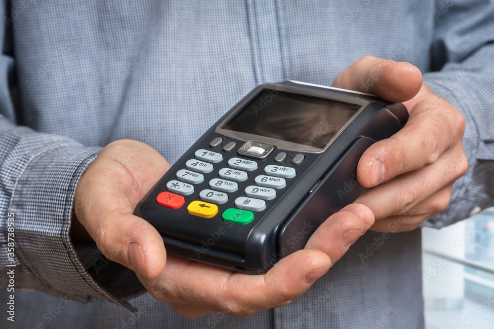 Payment terminal in hand of man Payment terminal in hand of man