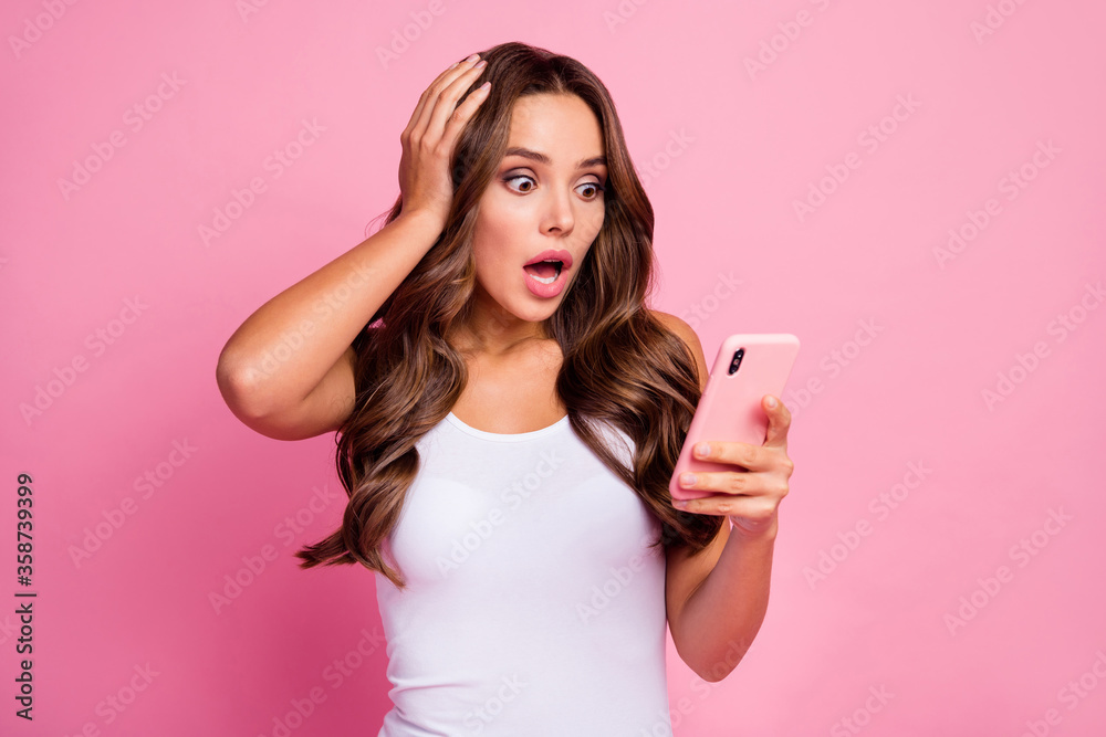 Photo of pretty crazy curly lady open mouth hold telephone read bad negative comments blog arm on head wear white casual singlet isolated pink color background Photo of pretty crazy curly lady open mouth hold telephone read bad negative comments blog arm on head wear white casual singlet isolated pink color background