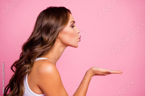 Profile photo of pretty attractive curly lady flirty mood send air kisses open palm flirting boyfriend tempting lips wear white casual singlet isolated bright pink color background
