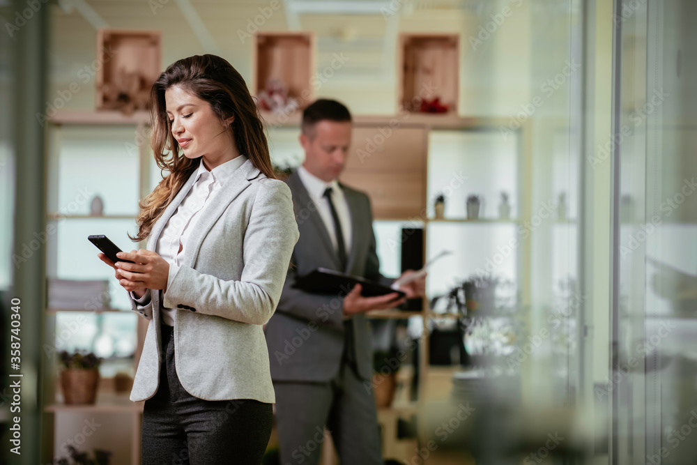 © JustLife - Businesswoman using the phone. Happy young woman working in office.
