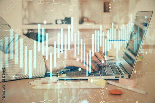 Double exposure of stock market graph with man working on laptop on background. Concept of financial analysis. © peshkova
