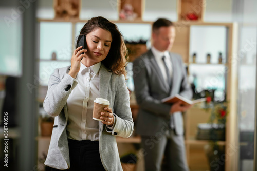Businesswoman talking to the phone. Happy young woman working in office. 