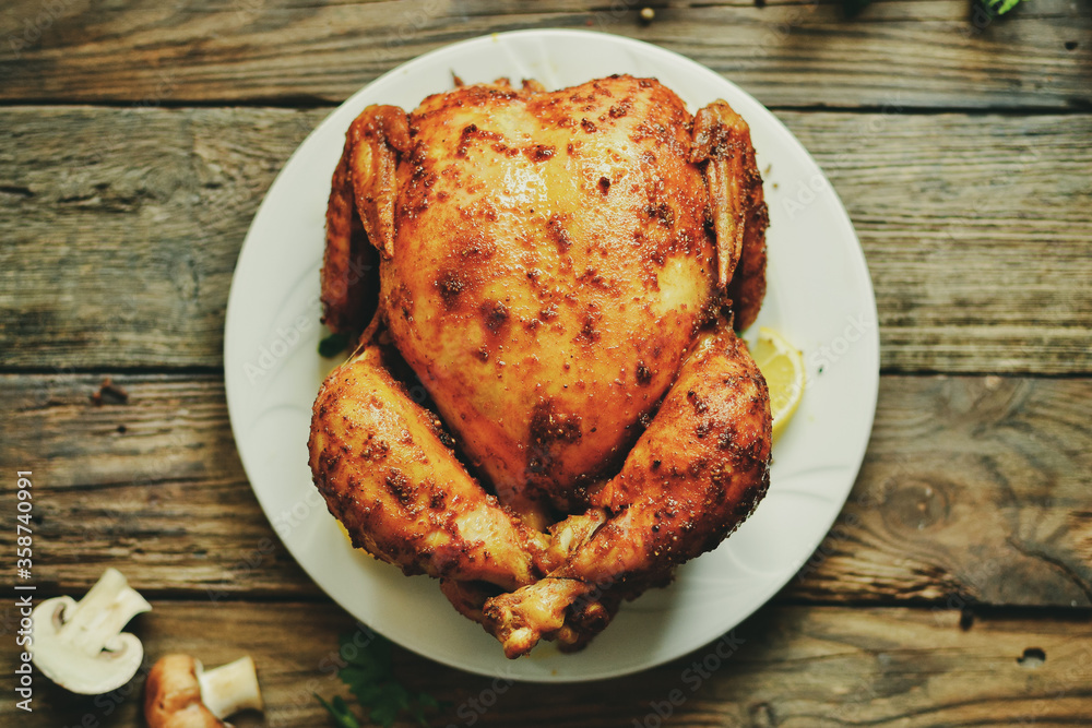 Whole baked chicken with crispy curry. Wooden background. Festive dinner. Whole baked chicken with crispy curry. Wooden background. Festive dinner.
