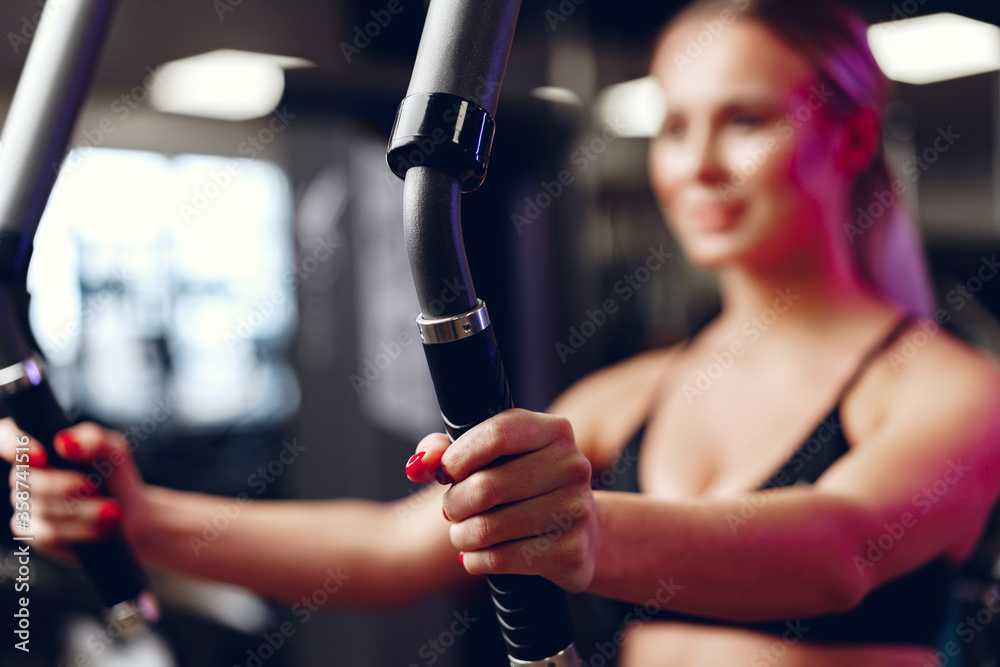 Blurred woman training arms and chest in a gym