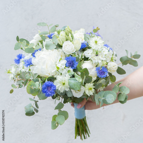 Bright bridal bouqet with white peonies, eucalyptus and exotic light green flowers. Close up maco shot. 