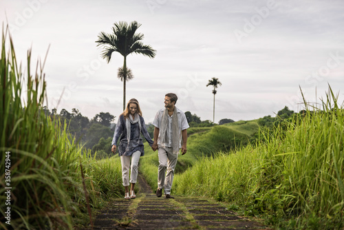 Asia, Indonesia, Bali, young Caucasian couple, wearing smart casual clothing, enjoying a walk along the famous Campuan ridge, one of the well known tourist attractions in Ubud.  photo