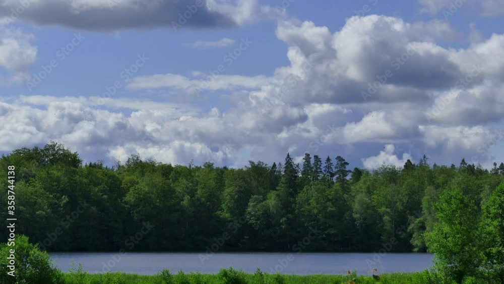 Timelapse of clouds moving fast over a lake and forest in Bjärnum, Sweden. Timelapse of clouds moving fast over a lake and forest in Bjärnum, Sweden.