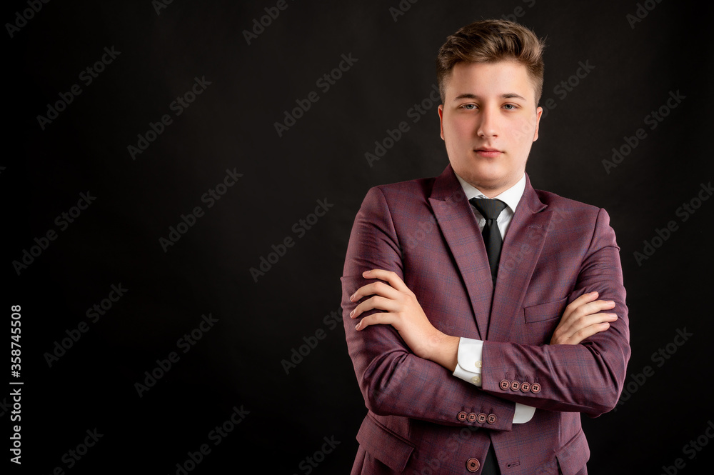 Fototapeta premium Law student with blond hair dressed in burgundy jacket, white shirt and black tie looking confident