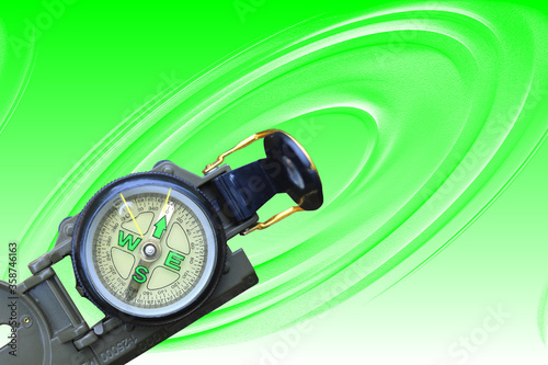 round compass as symbol of tourism, travel and outdoor activities on green background