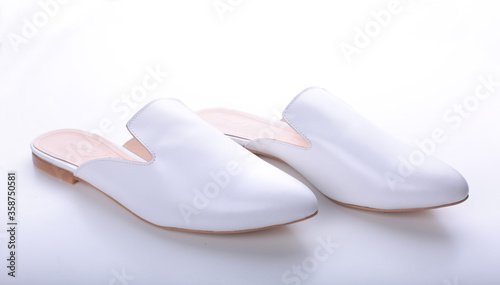 beautiful women's shoes on legs and layouts, leather white mules and loafers, in the interior of a room or office, a girl shoes, blue skirt and white shoes, a noble and elegant style, modern and trend