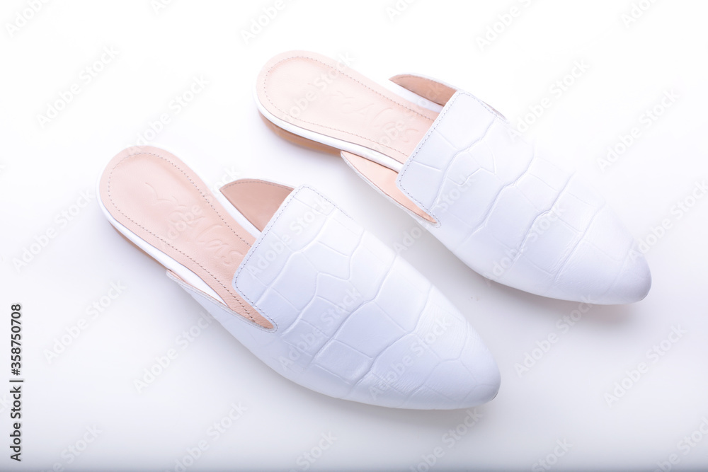 beautiful women's shoes on legs and layouts, leather white mules and loafers, in the interior of a room or office, a girl shoes, blue skirt and white shoes, a noble and elegant style, modern and trend