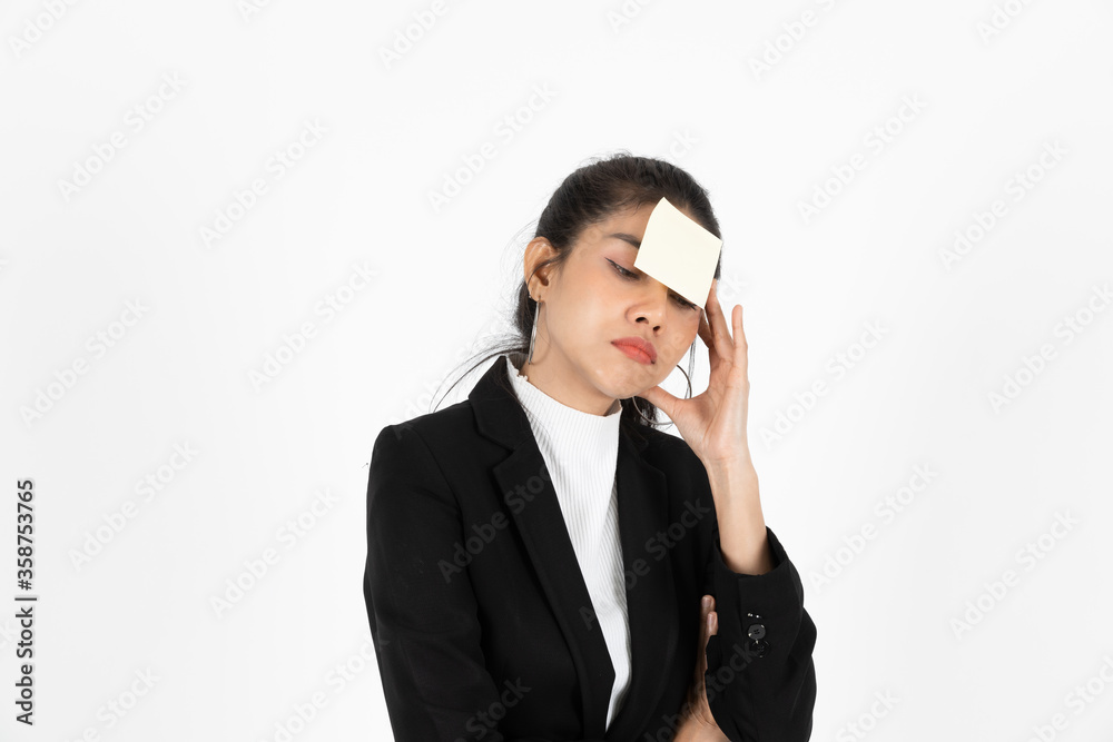 Exhausted tired young Asian business woman in formal wear with adhesive note on her forehead over white isolated background. Exhausted tired young Asian business woman in formal wear with adhesive note on her forehead over white isolated background.