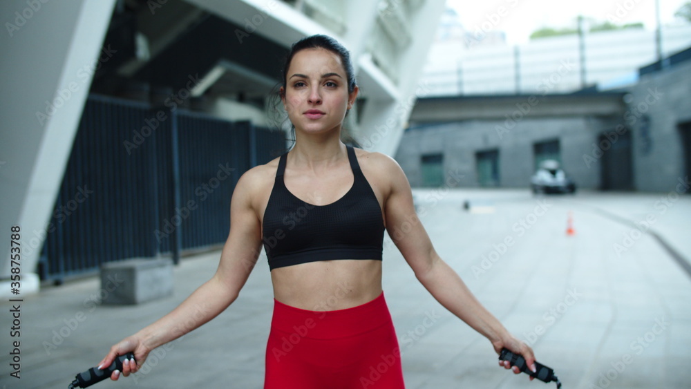 Fototapeta premium Athlete woman jumping with skipping rope. Sporty woman training cardio exercise