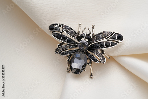Silver brooch shaped like a beetle, insect, bee , with small diamonds, isolated on white background
