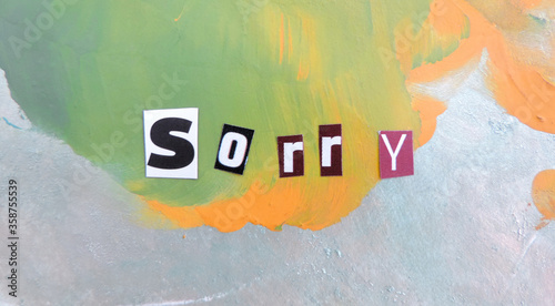 of the cut out letters is the word sorry on a colorful abstract background photo