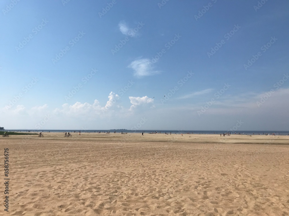 
large sandy beach, people and the sea on a sunny day