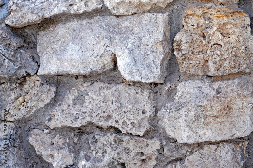 Masonry stone wall. Ancient medieval stone masonry. Texture of a fragment of a wall of an old structure. A background for design and creative work. Masonry stone wall. Ancient medieval stone masonry. Texture of a fragment of a wall of an old structure. A background for design and creative work.