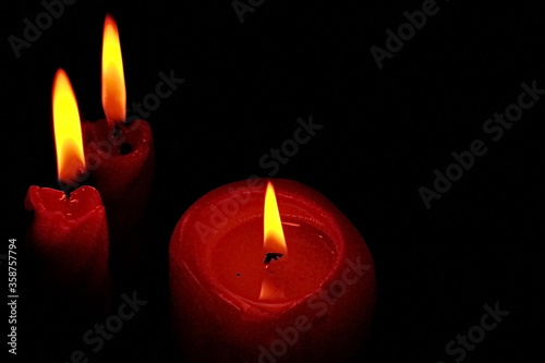  Three Burning Candles. Horizontal frame. Black background.