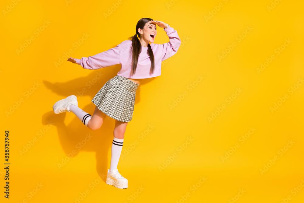 Full length body size view of her she nice attractive lovely fashionable cheerful cheery girl looking far away isolated over bright vivid shine vibrant yellow color background Full length body size view of her she nice attractive lovely fashionable cheerful cheery girl looking far away isolated over bright vivid shine vibrant yellow color background