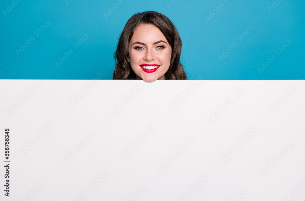 Closeup photo of pretty funny lady read empty advertisement banner novelty placard positive cheerful facial expression red lipstick isolated blue color background Closeup photo of pretty funny lady read empty advertisement banner novelty placard positive cheerful facial expression red lipstick isolated blue color background